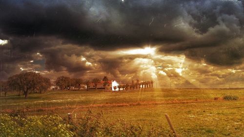 View of field against cloudy sky