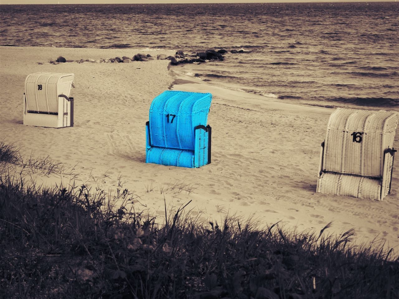 HIGH ANGLE VIEW OF HOODED BEACH CHAIRS ON SAND