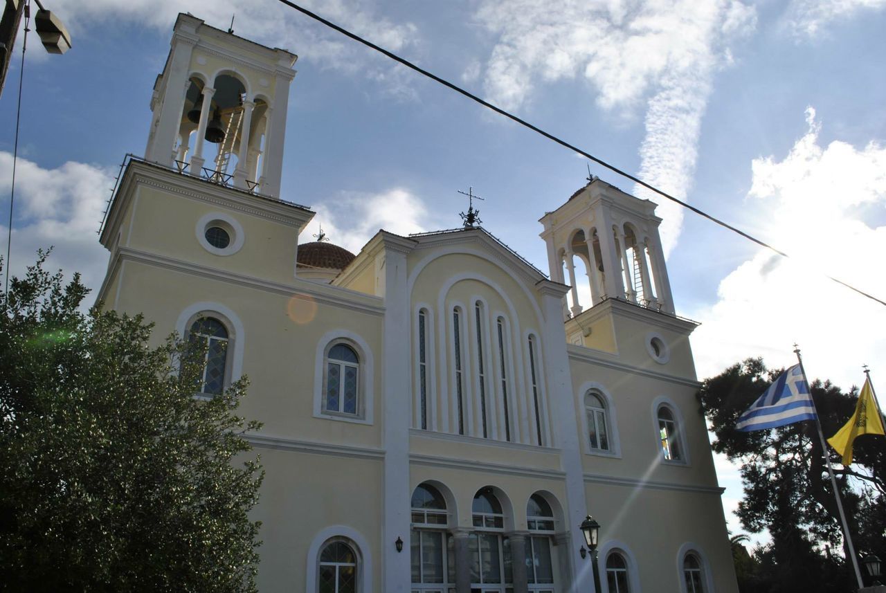 architecture, building exterior, religion, church, built structure, place of worship, low angle view, spirituality, sky, tree, cross, cathedral, cloud - sky, cloud, facade, outdoors, day, no people