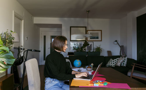 Businesswoman concentrating while working on laptop sitting at home