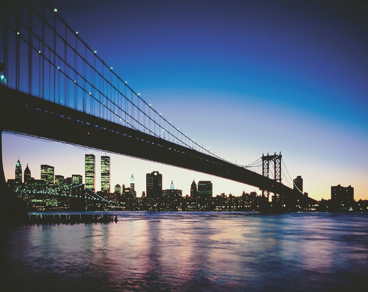 built structure, architecture, water, waterfront, connection, bridge - man made structure, clear sky, engineering, river, suspension bridge, bridge, city, copy space, sunset, building exterior, sea, sky, reflection, silhouette, blue