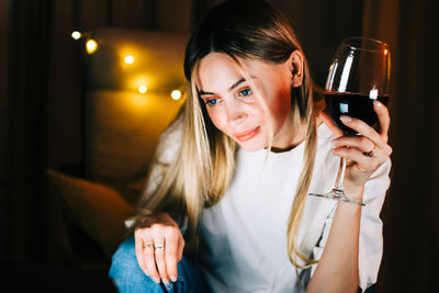 Portrait of a smiling young woman holding glass