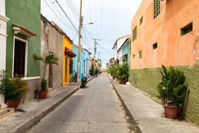 Road amidst buildings in city against clear sky