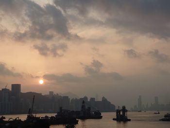 Scenic view of sea and buildings against sky during sunset