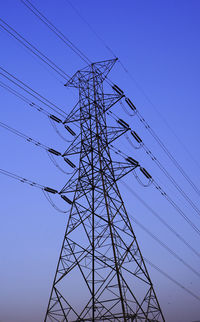 Low angle view of electricity pylon against clear sky