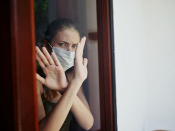 Portrait of a young woman holding window