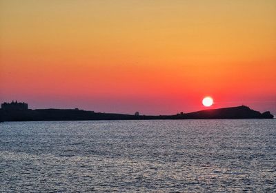 Scenic view of sea against orange sky