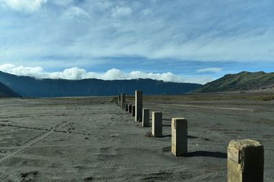 Wooden posts on mountain against sky