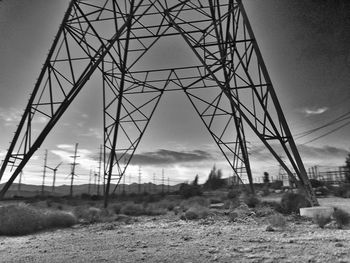 Low angle view of electricity pylon on field