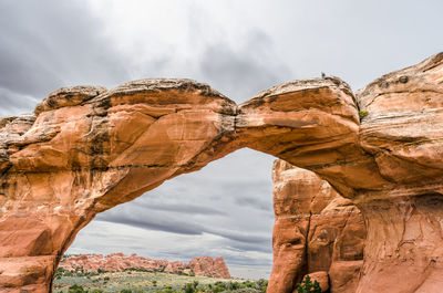 Low angle view of rock formations against cloudy sky