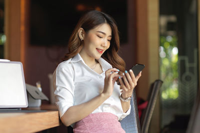 Woman looking away while using mobile phone