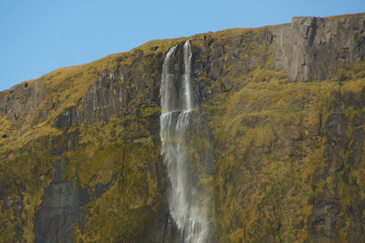 Scenic view of waterfall against clear sky
