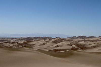 Scenic view of desert against clear blue sky