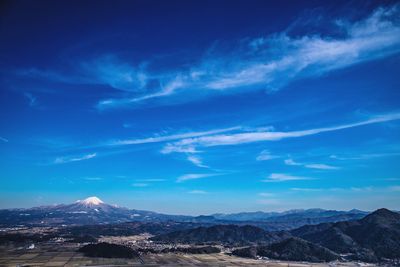 Scenic view of snowcapped mountains against blue sky