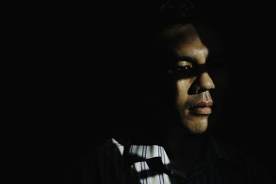 Close-up of young man against black background