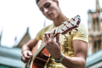 Midsection of man playing guitar