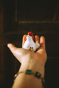 Close-up of woman hand holding toy chicken