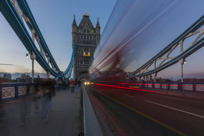 Blurred motion of illuminated bridge against sky in city