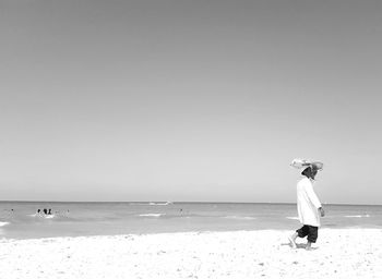 Full length of woman on beach against clear sky