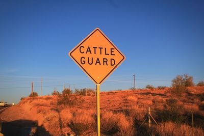 Road sign against clear blue sky