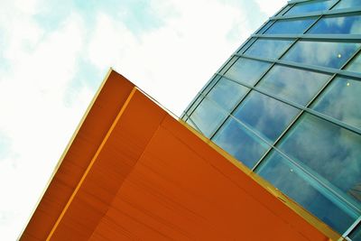 Low angle view of modern building against cloudy sky