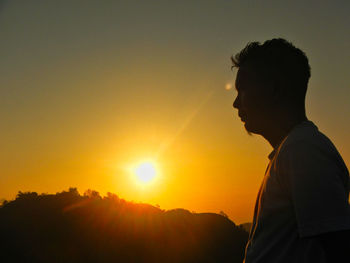 Silhouette man standing against sky during sunset