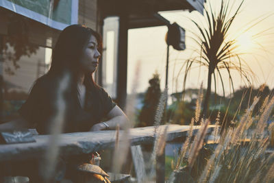 Thoughtful woman looking away during sunset