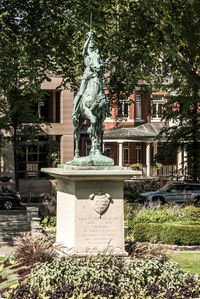 Statue by fountain against plants