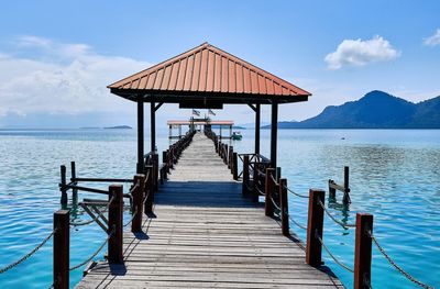 Wooden pier on sea against sky