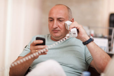 Businessman talking on landline phone 