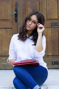 Portrait of young woman sitting outdoors