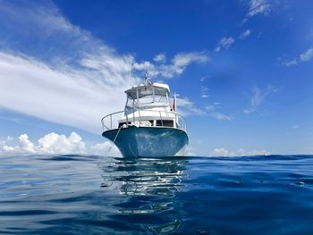 Low angle view of yacht moored on sea against blue sky