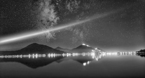 Scenic view of lake against sky at night