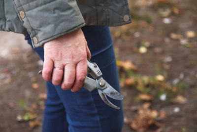 Gardening scissors. female hand holding gardening scissors. gardener with pruning shears in hand. 