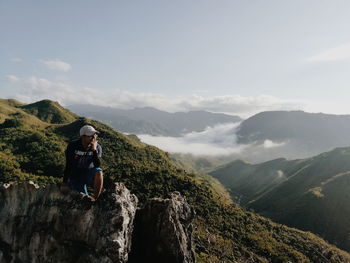 Man looking at mountains against sky