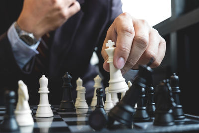 Midsection of businessman playing chess