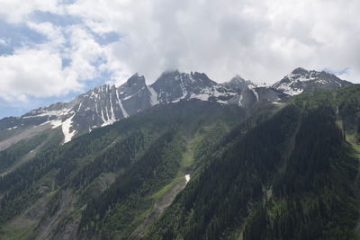 Scenic view of mountains against cloudy sky