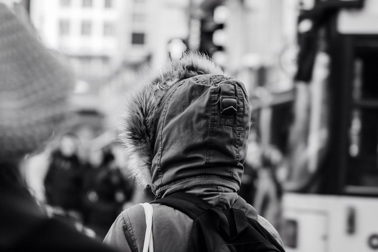 focus on foreground, men, lifestyles, leisure activity, rear view, building exterior, holding, city, person, street, incidental people, built structure, architecture, unrecognizable person, close-up, selective focus, day