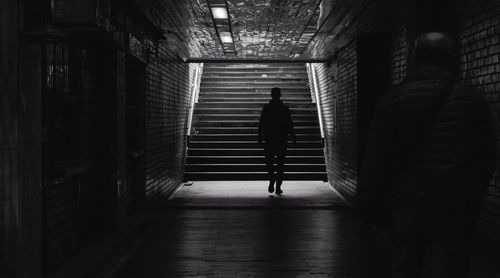 Rear view of man walking in underground walkway