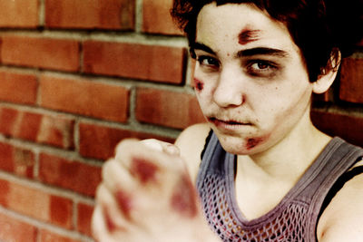 Portrait of young man against brick wall