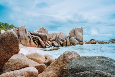 Rocks at beach against sky