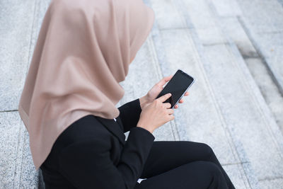 Midsection of man using mobile phone