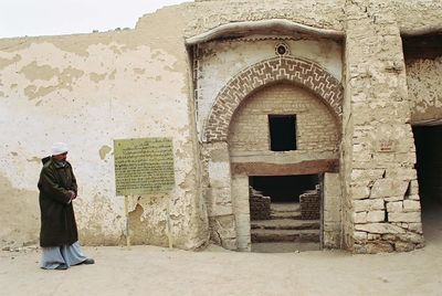 Full length of man standing against built structure