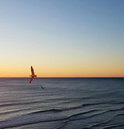 Scenic view of sea against clear sky at sunset