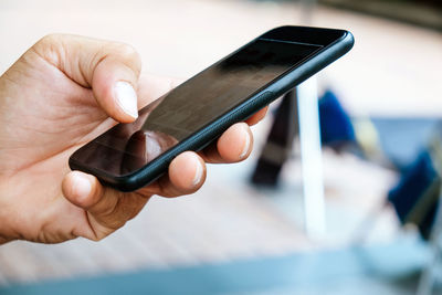 Close-up of hand holding mobile phone