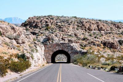 Empty road leading towards archway at big bend national park