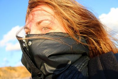 Woman covering face with jacket