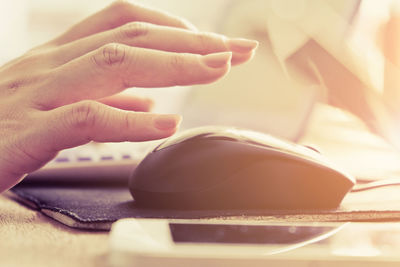 Cropped hand with computer mouse on desk