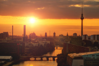 View of cityscape against cloudy sky during sunset