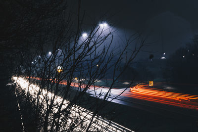 Light trails on road against sky at night